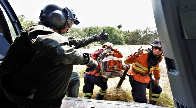 Grupo de bombeiros se desloca de helicóptero para uma área alagada na RPPN da Caiman