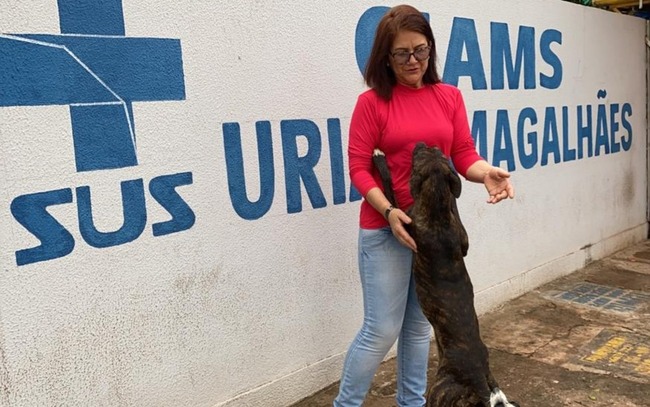 Cachorro que fica na porta de Cais pede carinho para a comerciante Maria Azevedo, em Goiânia, Goiás — Foto: Lis Lopes/G1