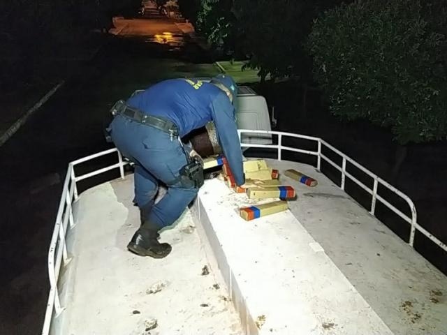 Policial retira tabletes de maconha apreendida hoje em Dourados (Foto: Adilson Domingos)