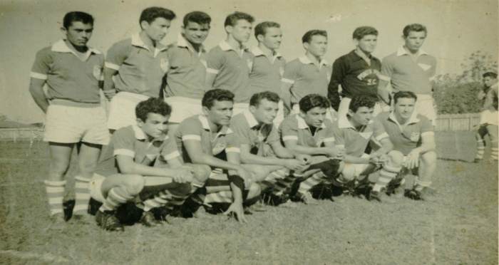 Arquivo pessoal Adão Bueno: nesta foto Omenélio Bueno aparece ao fundo, mão na cintura analisando a equipe adversária, no momento que os outros colegas da equipe do Ponta Porã faziam pose para foto, com atletas que fizeram história em seu tempo. Em pé da esquerda para direita Elidio, Saturnino, lacuna, goleiro de preto Zé Quintana Bertolino Bueno irmão de Omenéilio, agachado da direta para esquerda o Erve Roncatt, Roberval Roncatti, Coque entre outros grandes atletas deste tempo.